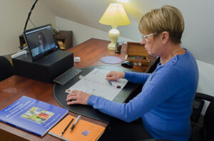 Brigitte du Castel, en lecture d'aura à distance, devant son ordinateur